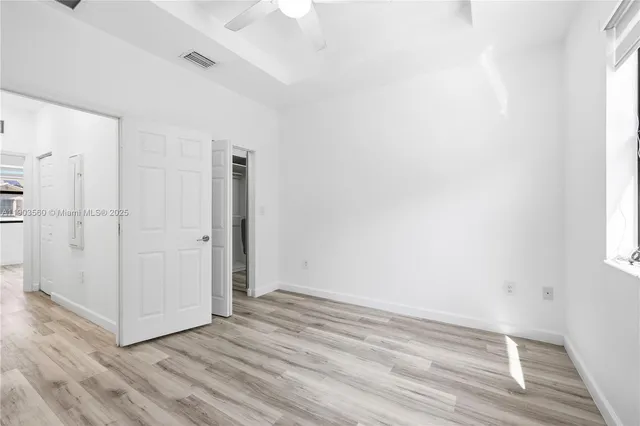 a view of empty room with wooden floor