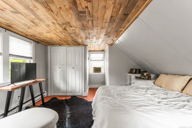 a bedroom with a bed and large windows