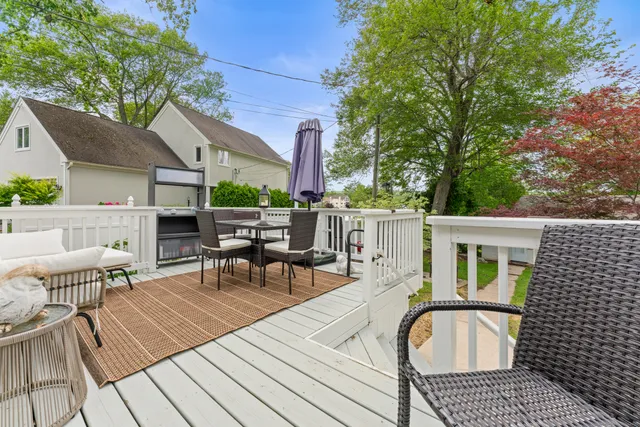 a view of a patio with a dining table and chairs with wooden floor and fence