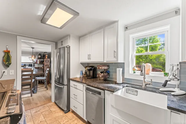 a kitchen with granite countertop a refrigerator and a sink