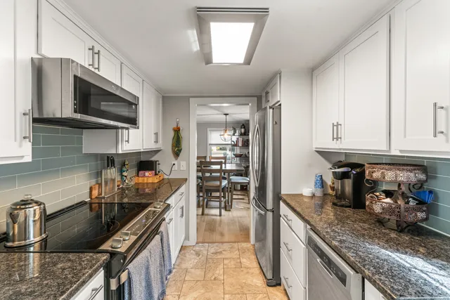 a kitchen with stainless steel appliances granite countertop a sink stove and refrigerator