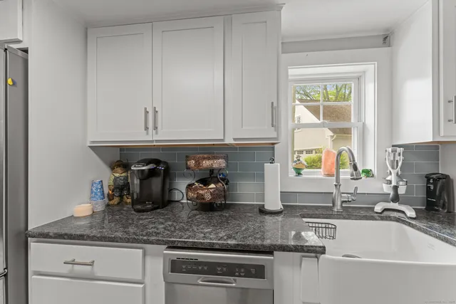 a kitchen with granite countertop a sink and cabinets