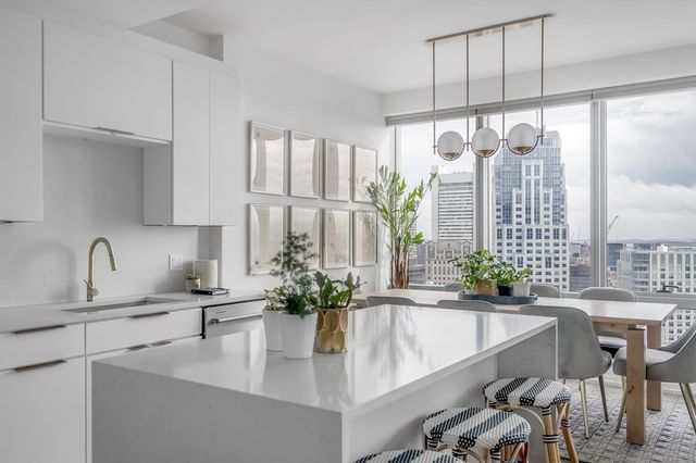 a kitchen with a table chairs and white cabinets