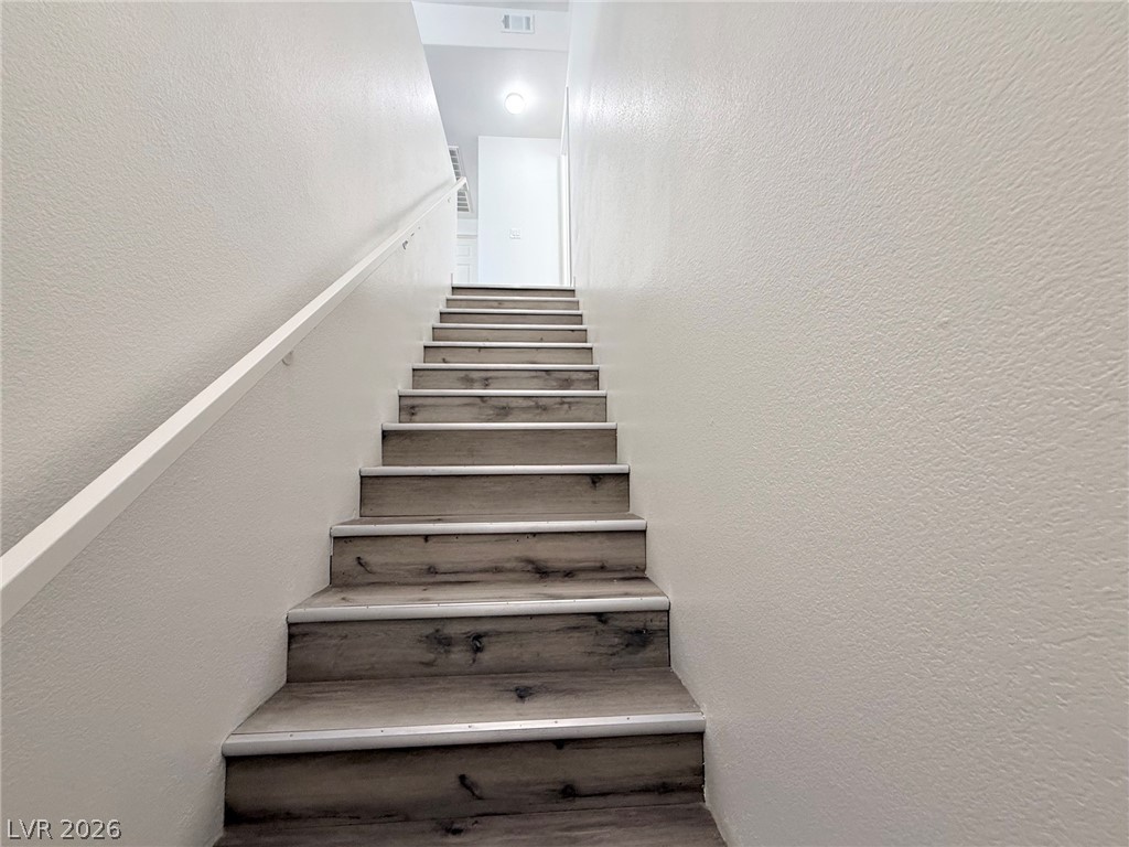 9050 West Warm Springs Road, Unit 2002 Las Vegas, NV 89148 - Photo 6 of 46 Ascend to comfort with modern wood plank stairs leading to inviting spaces.