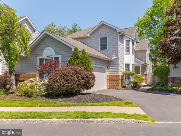 a view of a house with a yard and large tree