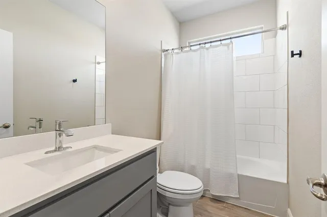 a bathroom with a sink a toilet a mirror and shower