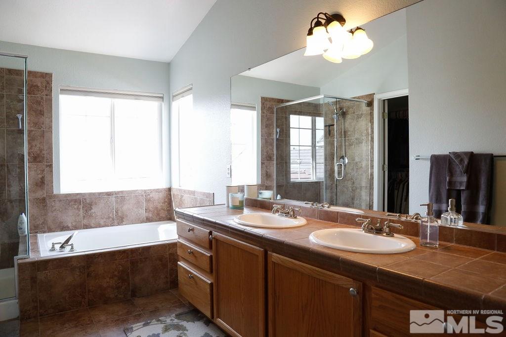 9841 Eastmont Court Reno, NV 89521 - Photo 21 of 38 a bathroom with a granite countertop sink mirror and a bathtub