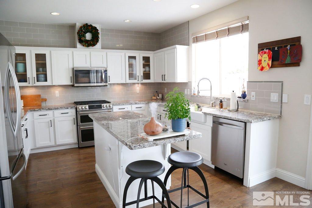 9841 Eastmont Court Reno, NV 89521 - Photo 3 of 38 a kitchen with stainless steel appliances granite countertop a white cabinets and a stove top oven