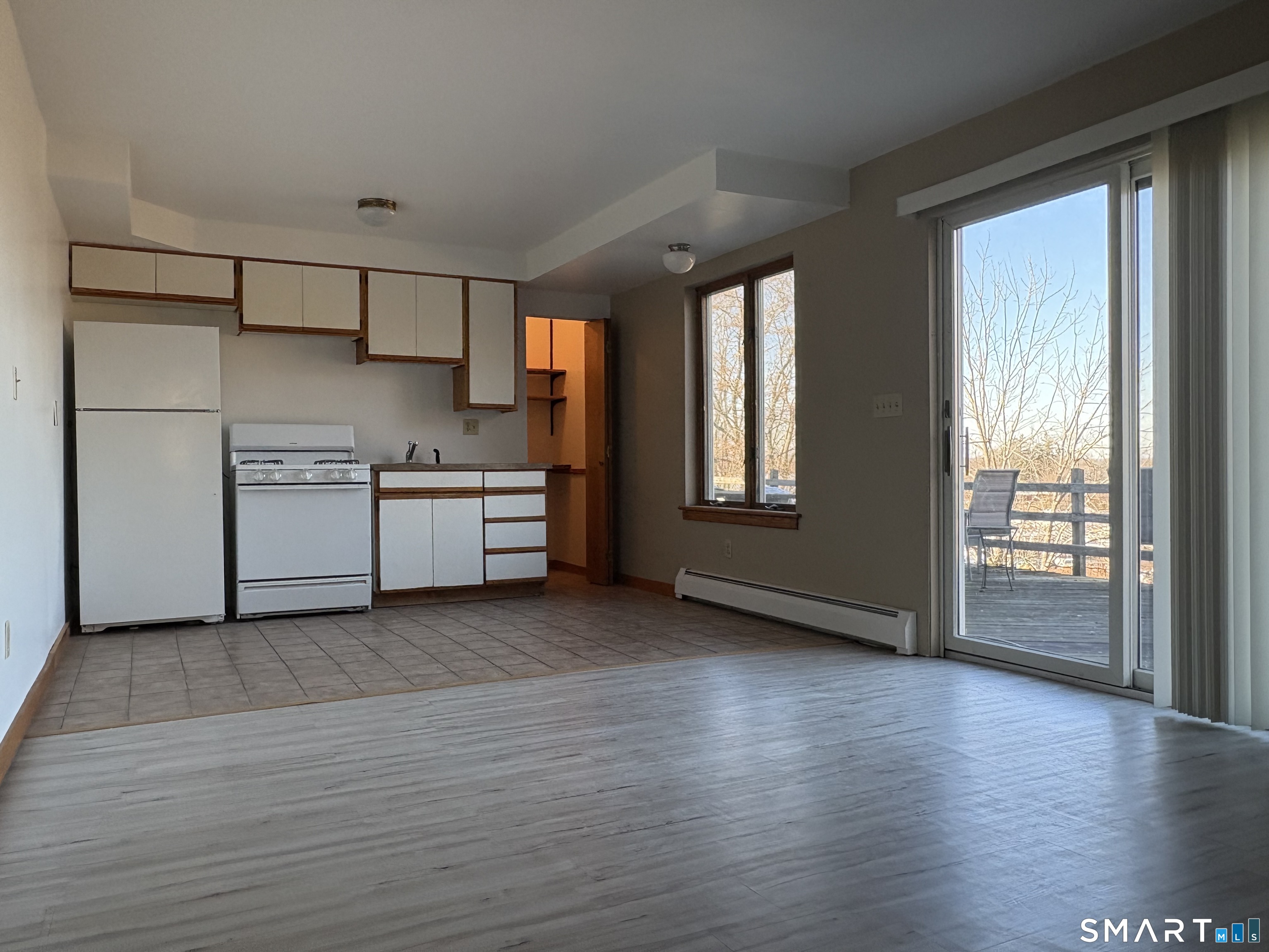 a view of a kitchen with a stove wooden cabinets and wooden floor