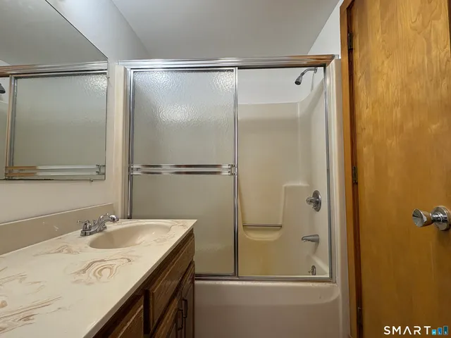 a bathroom with a granite countertop sink mirror and shower
