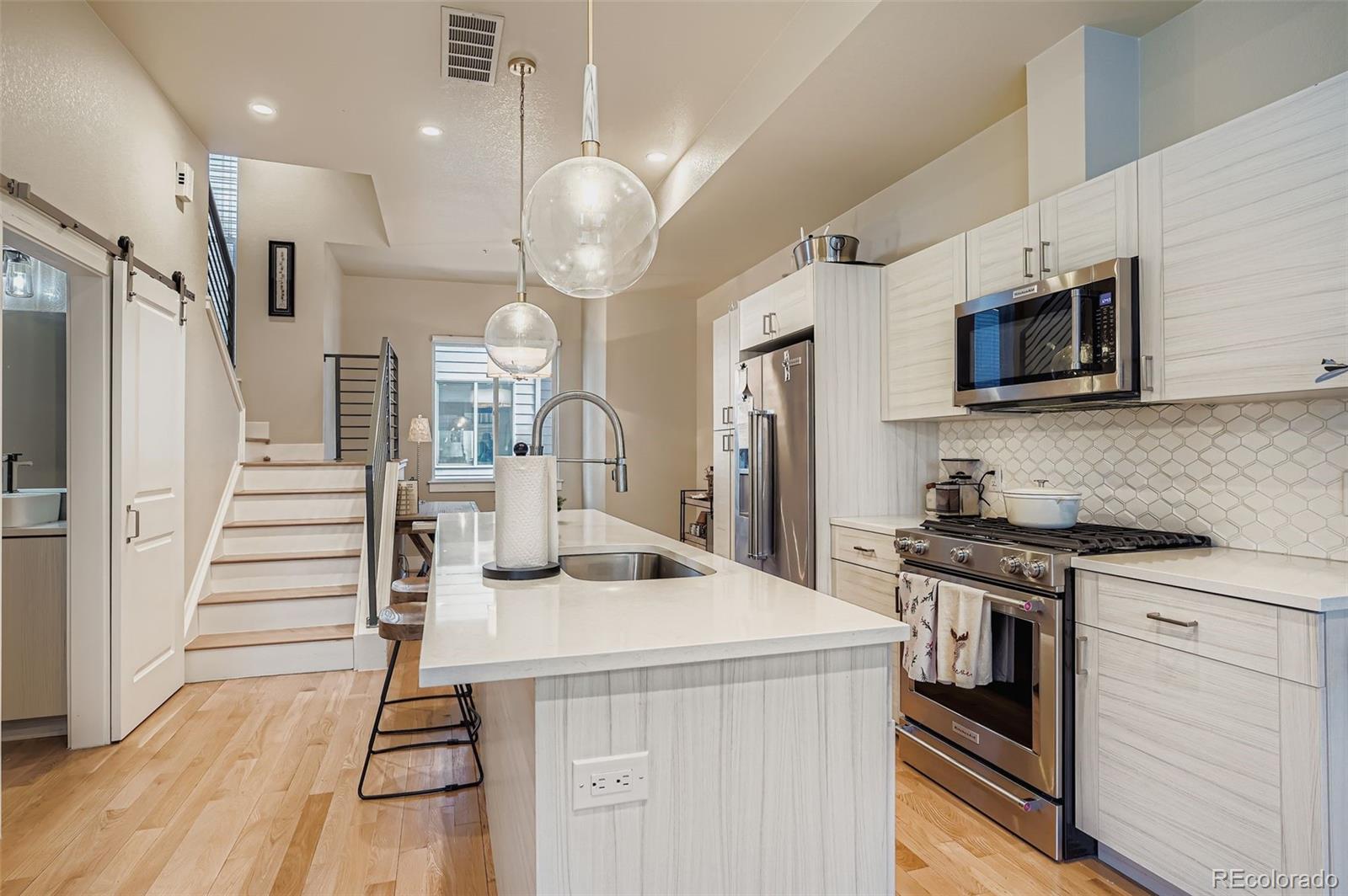 2739 West 24th Avenue, Unit 7 Denver, CO 80211 - Photo 13 of 31 a kitchen with stainless steel appliances kitchen island granite countertop a stove a sink and a refrigerator