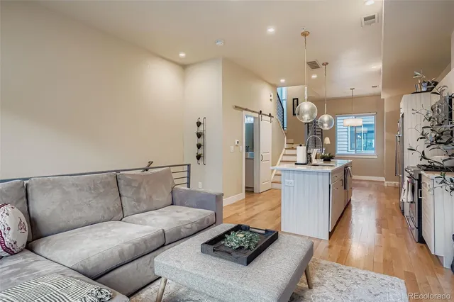 a living room with furniture and a view of kitchen