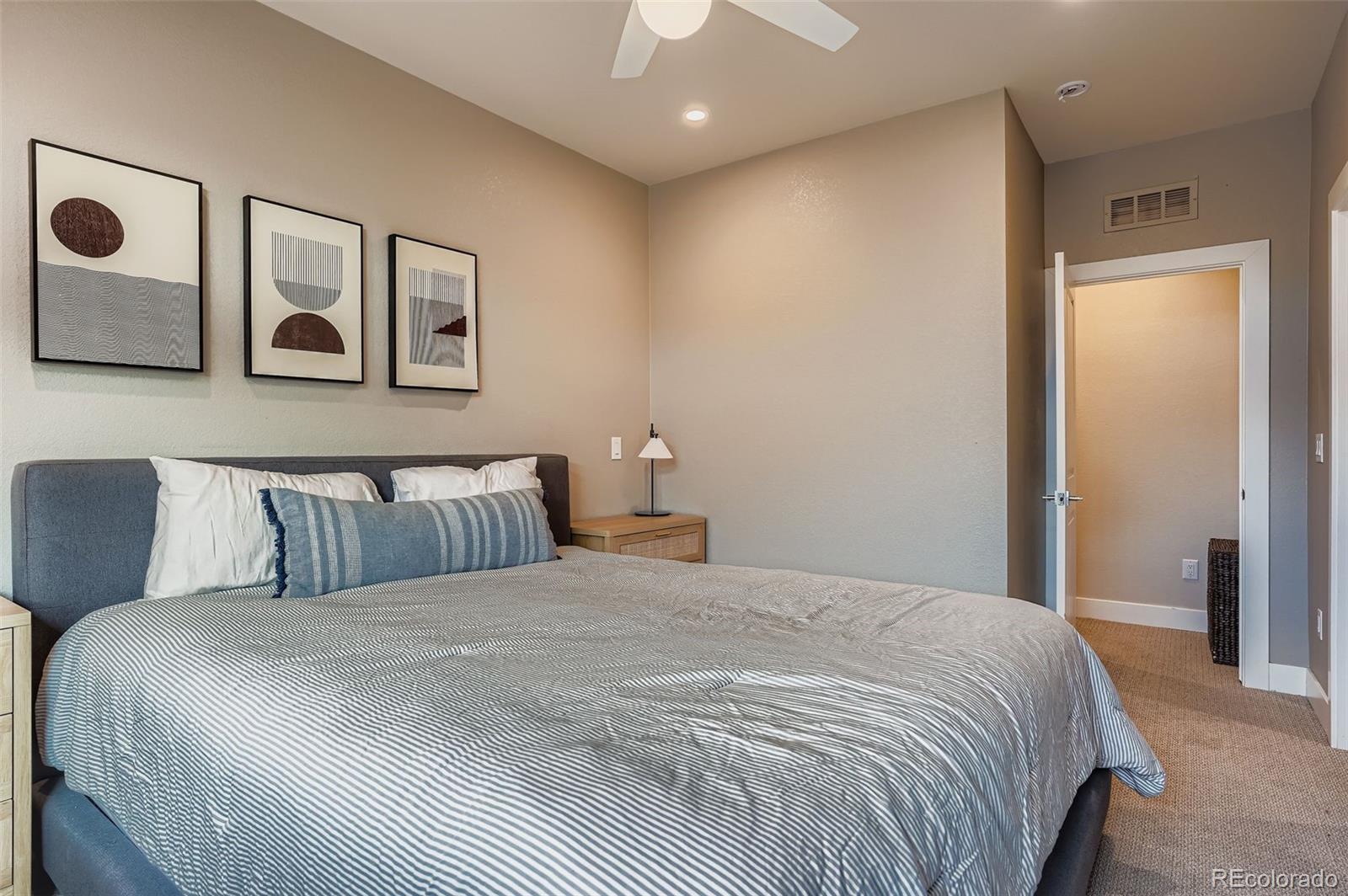 2739 West 24th Avenue, Unit 7 Denver, CO 80211 - Photo 18 of 31 a bedroom with a large bed and a chandelier