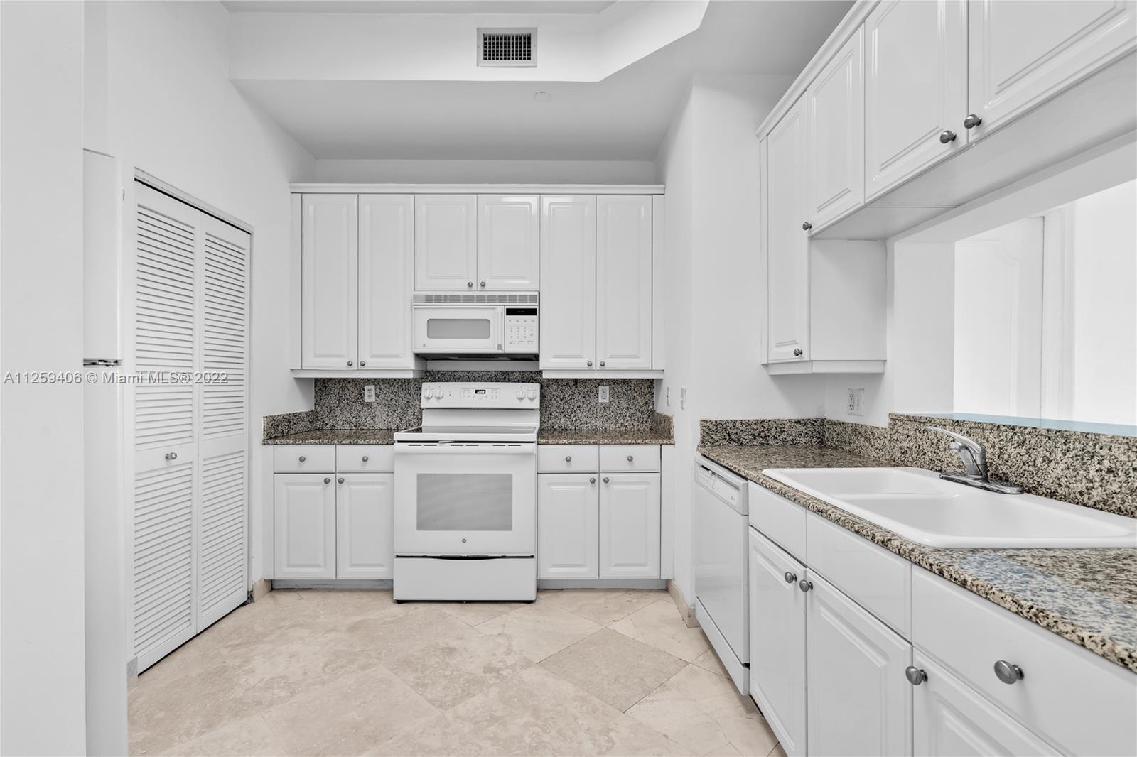 888 Brickell Key Drive, Unit 2610 Miami, FL 33131 - Photo 11 of 31 a kitchen with granite countertop white cabinets white stainless steel appliances with a sink and dishwasher