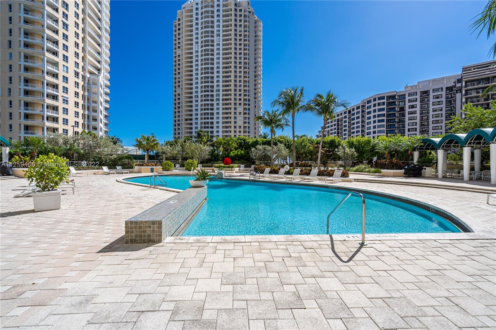 888 Brickell Key Drive, Unit 2610 Miami, FL 33131 - Photo 26 of 31 a swimming pool with lawn chairs and potted plants