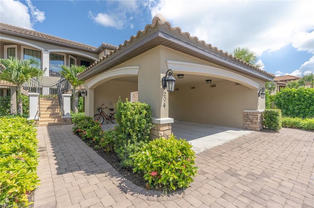 9419 Benvenuto Court, Unit 204 Naples, FL 34119 - Photo 17 of 50 View of front of house with stucco siding, a tiled roof, stairway, and stone siding