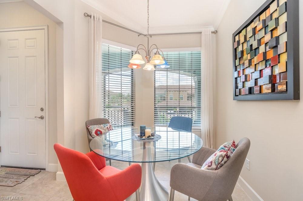 9419 Benvenuto Court, Unit 204 Naples, FL 34119 - Photo 20 of 50 Dining room featuring a chandelier and tile patterned flooring
