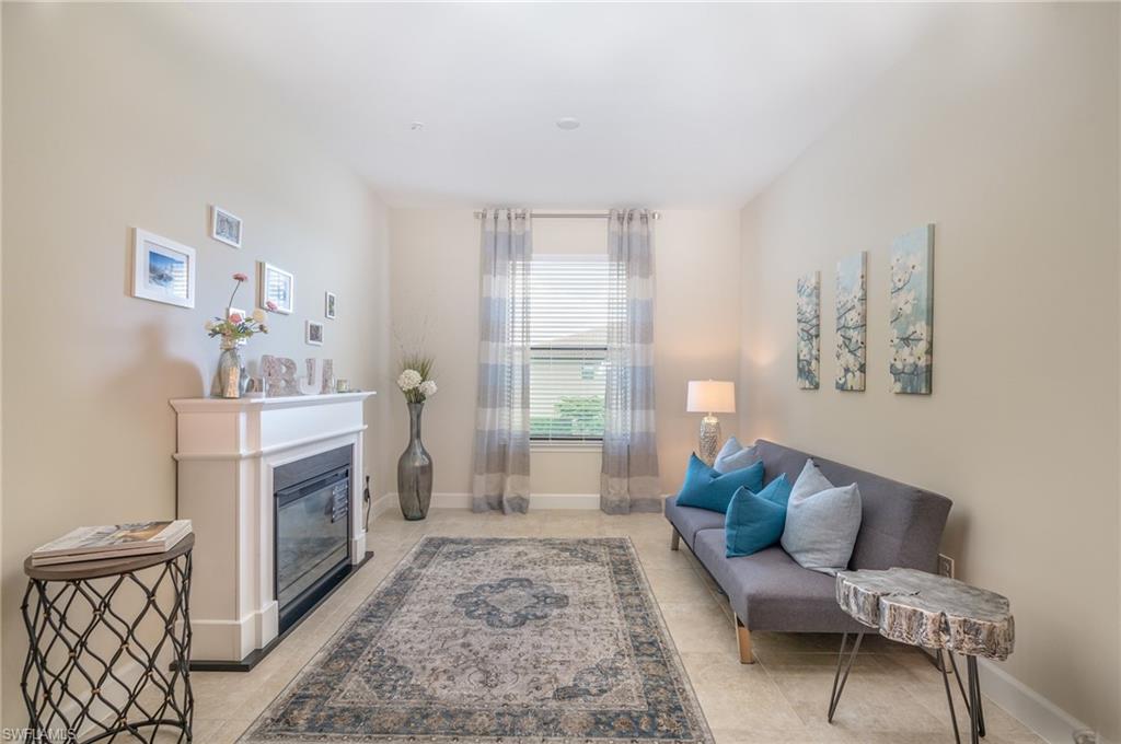 9419 Benvenuto Court, Unit 204 Naples, FL 34119 - Photo 28 of 50 Living area featuring a glass covered fireplace and light tile patterned flooring