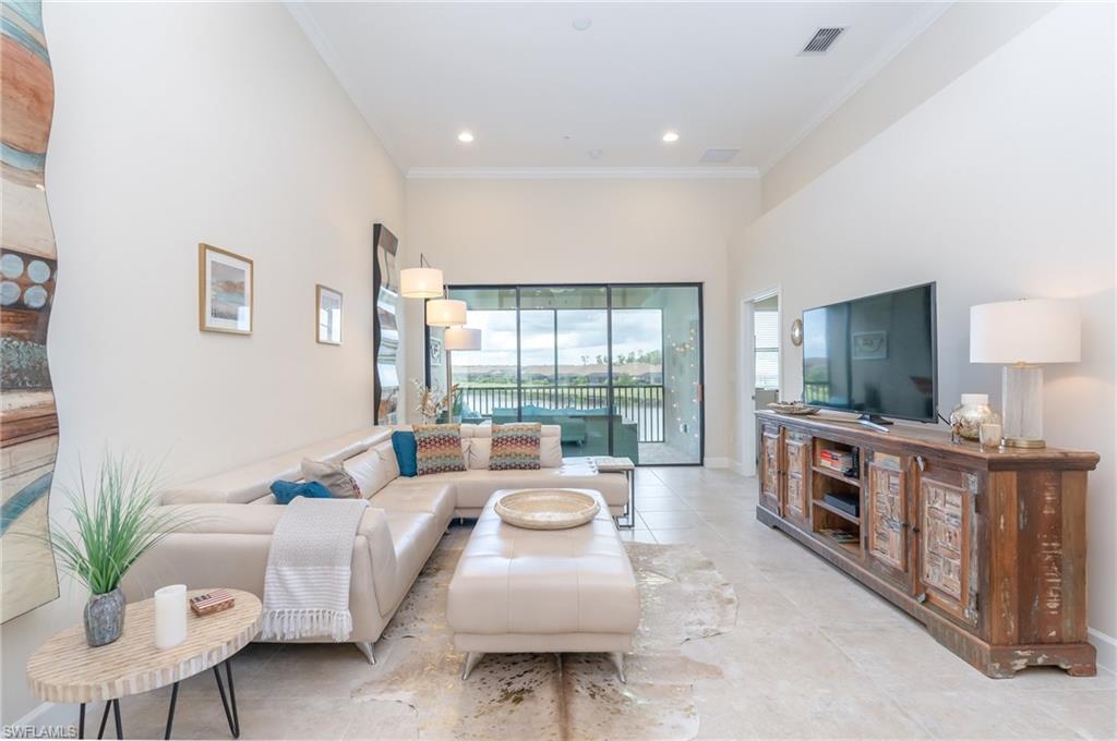 9419 Benvenuto Court, Unit 204 Naples, FL 34119 - Photo 32 of 50 Tiled living area with crown molding, recessed lighting, and a towering ceiling