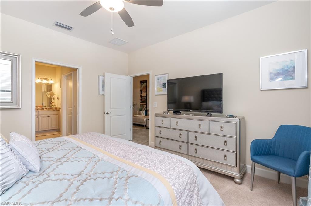 9419 Benvenuto Court, Unit 204 Naples, FL 34119 - Photo 37 of 50 Bedroom with light colored carpet, ceiling fan, and ensuite bath