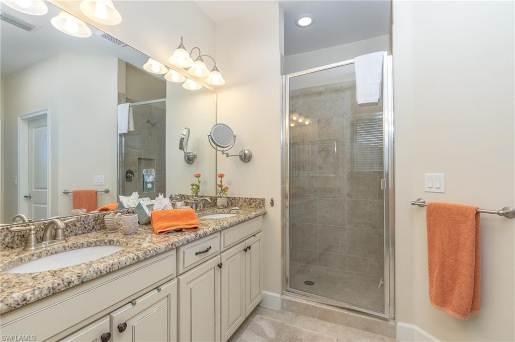 9419 Benvenuto Court, Unit 204 Naples, FL 34119 - Photo 39 of 50 Full bath with a shower stall, double vanity, and light tile patterned flooring