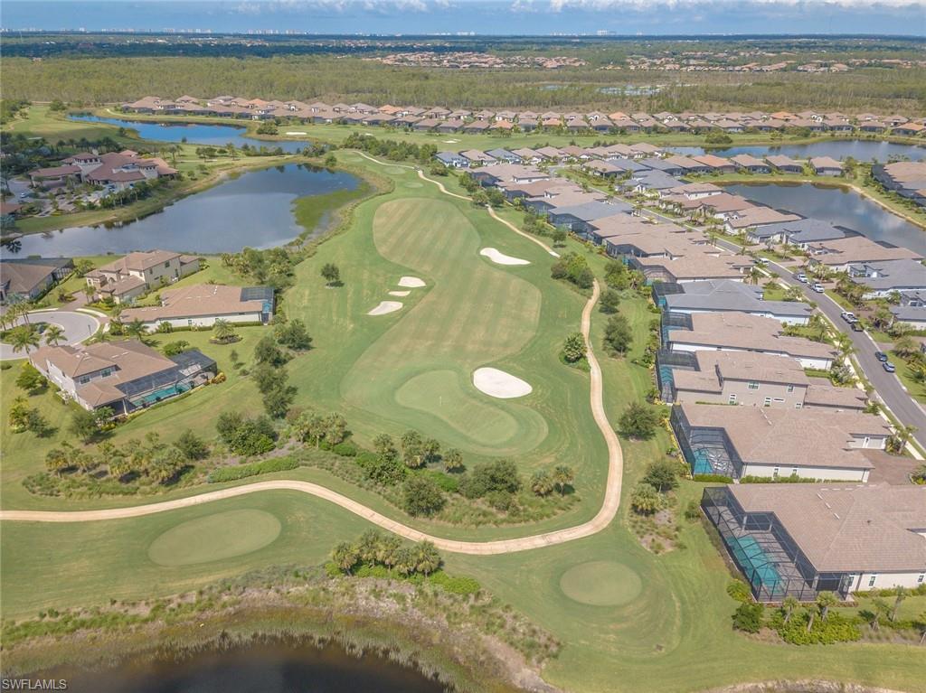 9419 Benvenuto Court, Unit 204 Naples, FL 34119 - Photo 49 of 50 Aerial view of property and surrounding area featuring a nearby body of water, nearby suburban area, and a local golf course