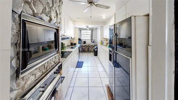 a view of an empty room with a chandelier fan