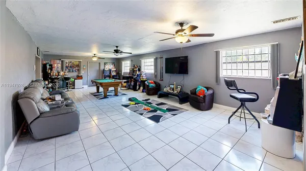 a living room with furniture a flat screen tv and a dining table