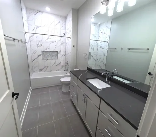 a bathroom with a sink a toilet a mirror and shower