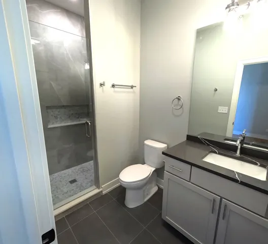 a bathroom with a granite countertop sink toilet and shower