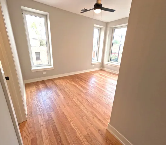 a view of an empty room and wooden floor and a window