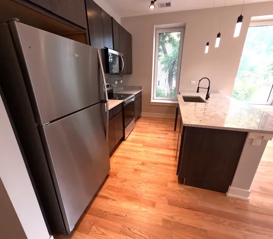 a kitchen with stainless steel appliances a refrigerator sink and microwave