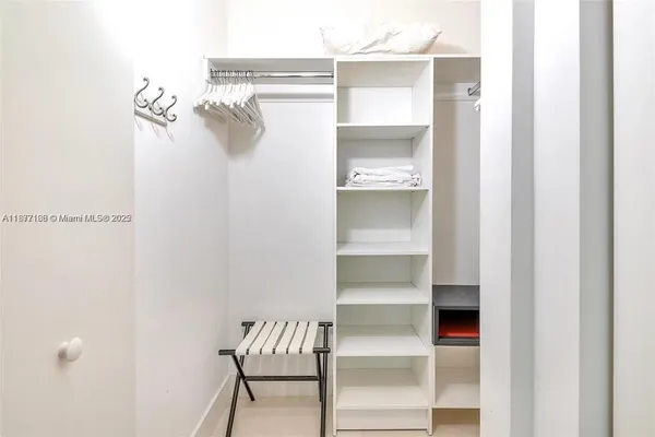 a bedroom with two beds and large windows