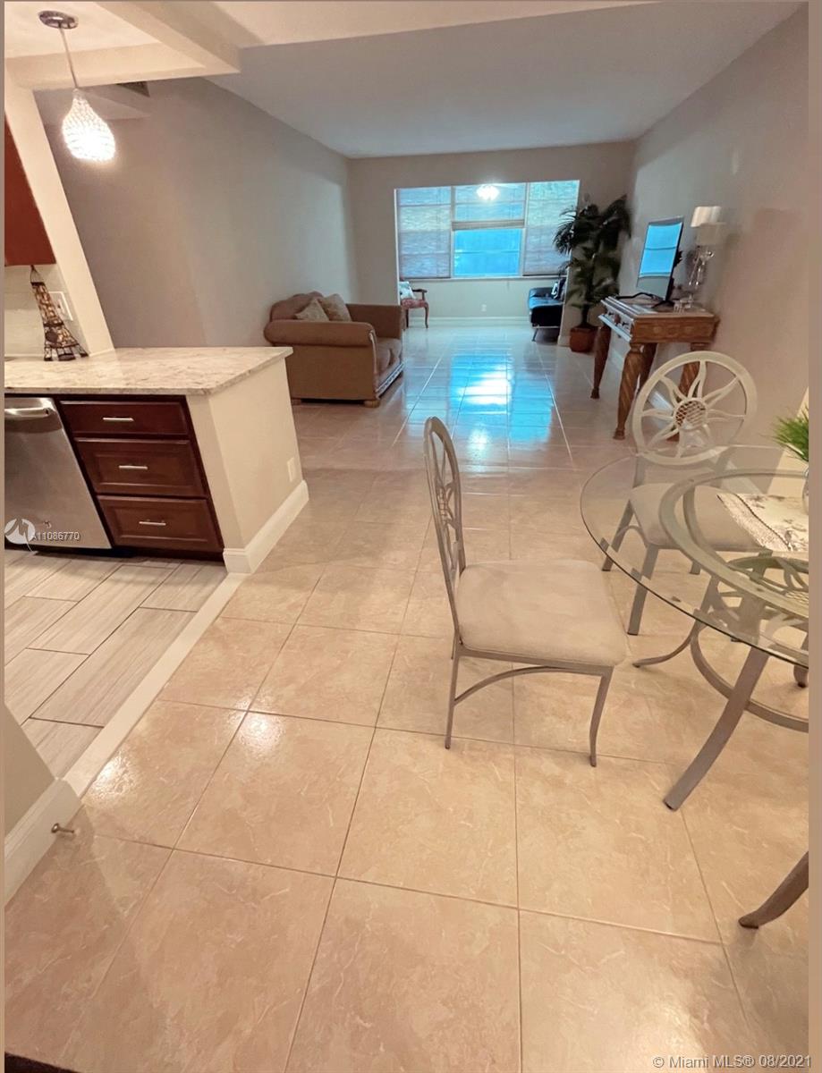 6700 Cypress Road, Unit 105 Plantation, FL 33317 - Photo 2 of 26 a living room with furniture and a table