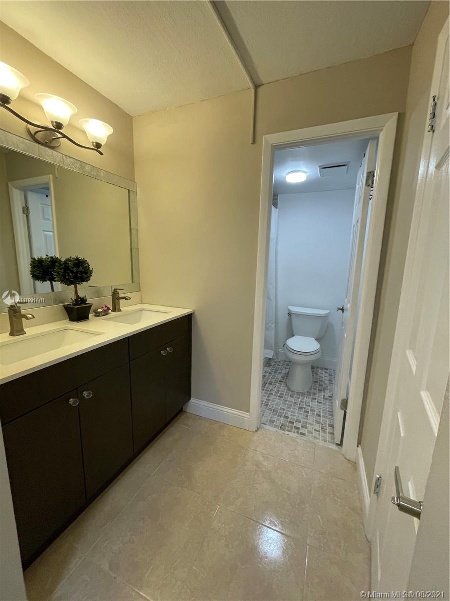6700 Cypress Road, Unit 105 Plantation, FL 33317 - Photo 14 of 26 a bathroom with a sink a toilet and a mirror