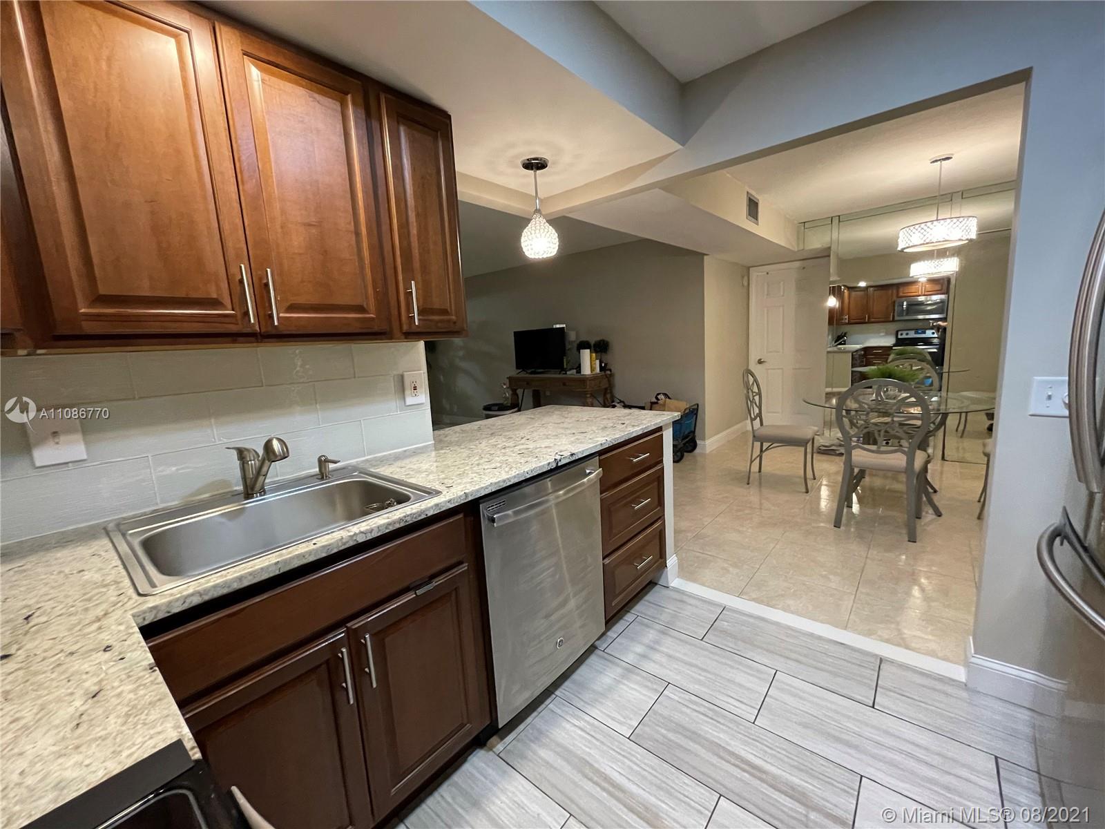 6700 Cypress Road, Unit 105 Plantation, FL 33317 - Photo 5 of 26 a kitchen with a sink appliances and cabinets