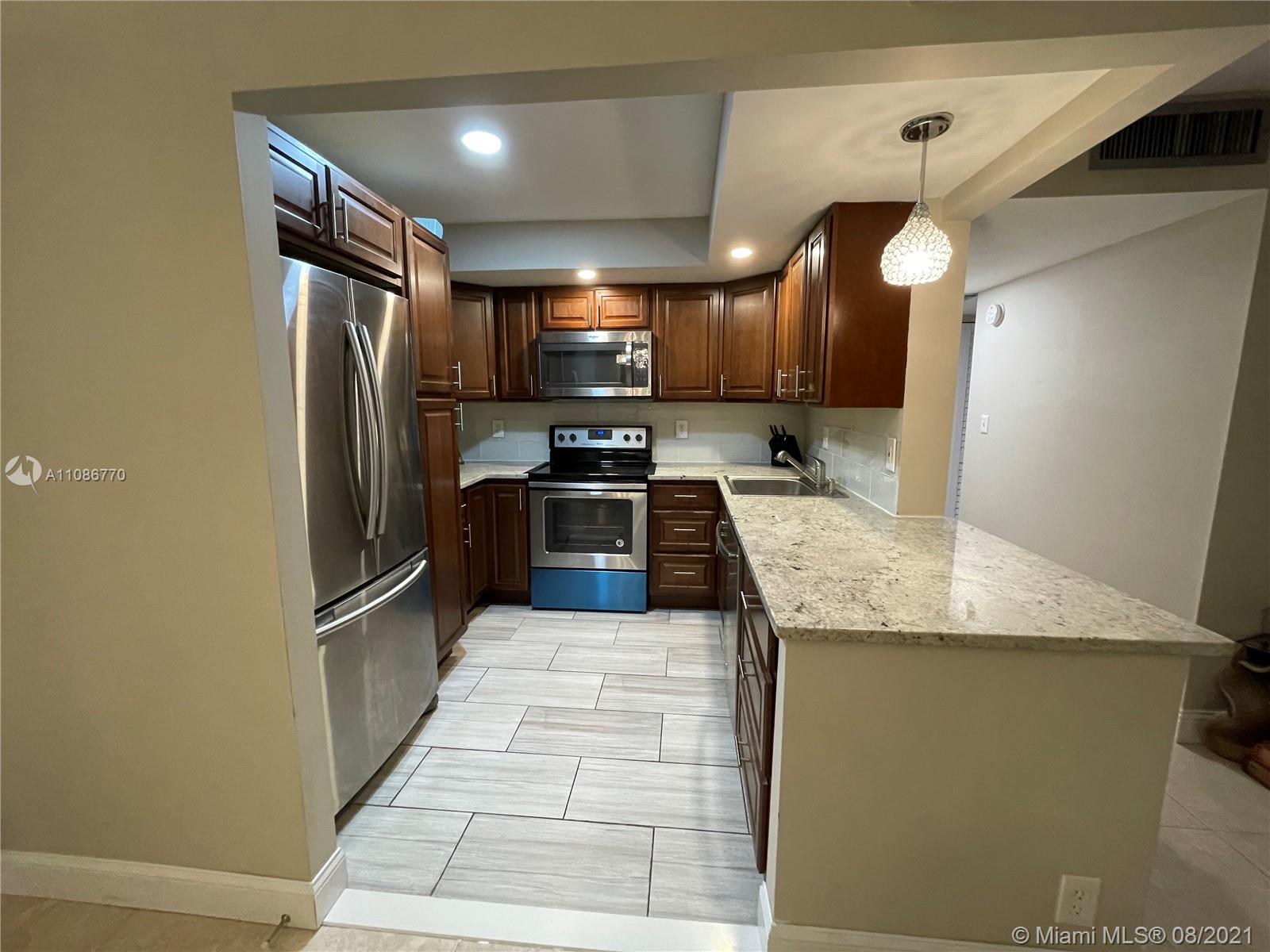 6700 Cypress Road, Unit 105 Plantation, FL 33317 - Photo 6 of 26 a kitchen with stainless steel appliances granite countertop a sink refrigerator and cabinets