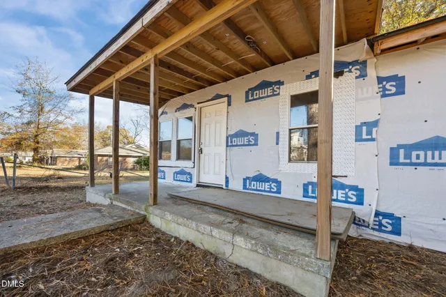 a front view of a house with a tree
