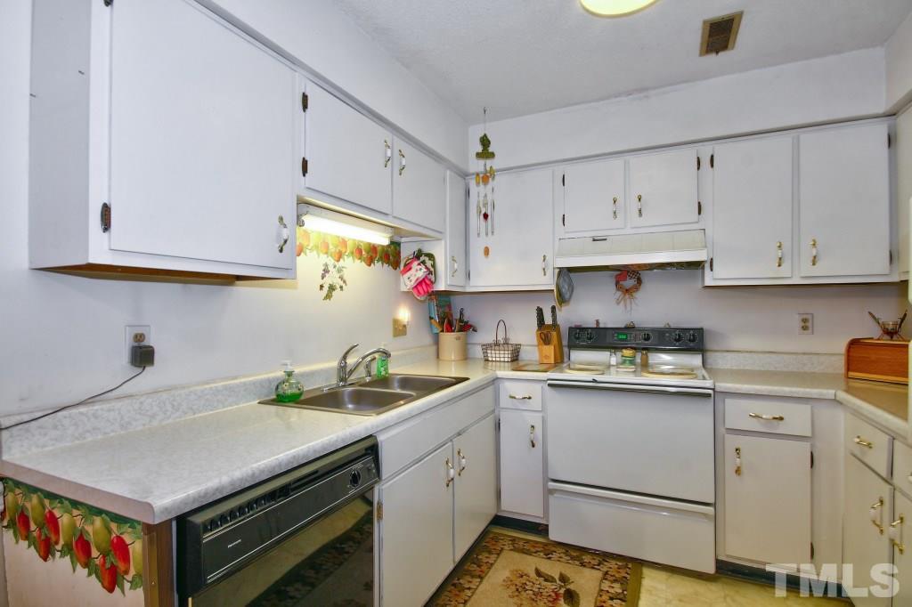 4331 Lake Ridge Drive, Unit NONE Raleigh, NC 27604 - Photo 8 of 14 a kitchen with white cabinets and white appliances