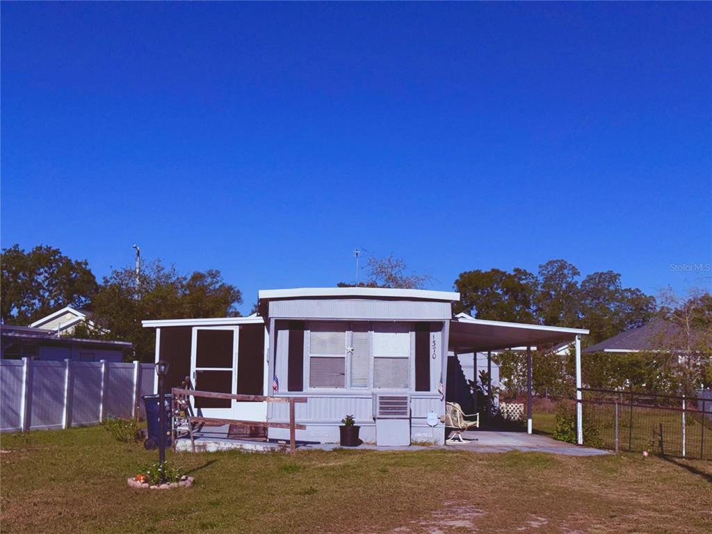 1370 County Drive Tavares, FL 32778 - Photo 12 of 12 a front view of a house with a yard outdoor seating and garage