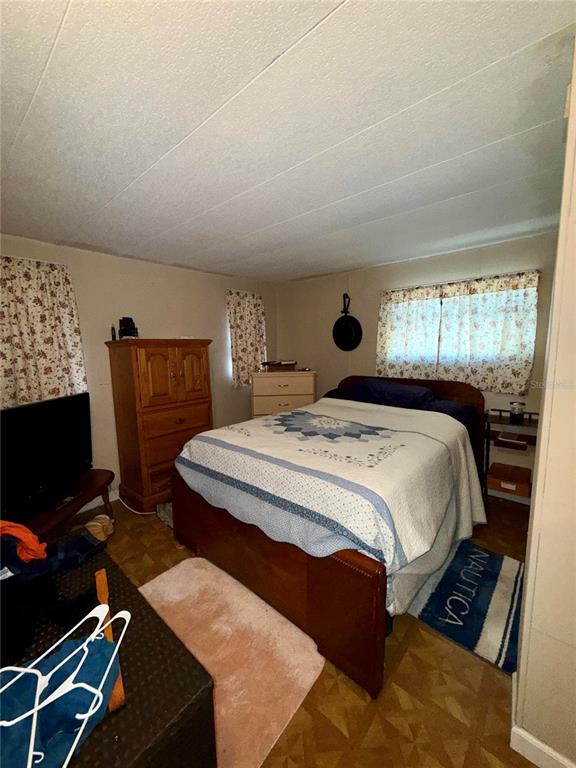 1370 County Drive Tavares, FL 32778 - Photo 7 of 12 a bedroom with a bed and a flat screen tv