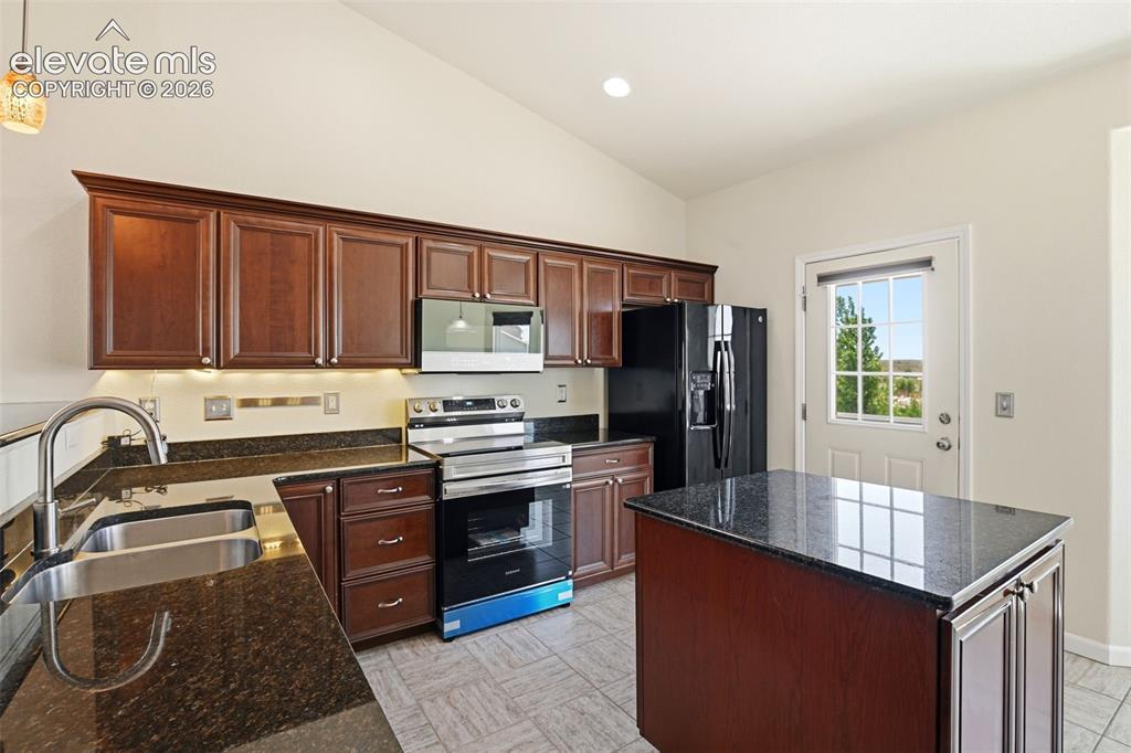 7806 Dutch Loop Colorado Springs, CO 80925 - Photo 7 of 41 a kitchen with stainless steel appliances granite countertop a stove a sink dishwasher and a refrigerator