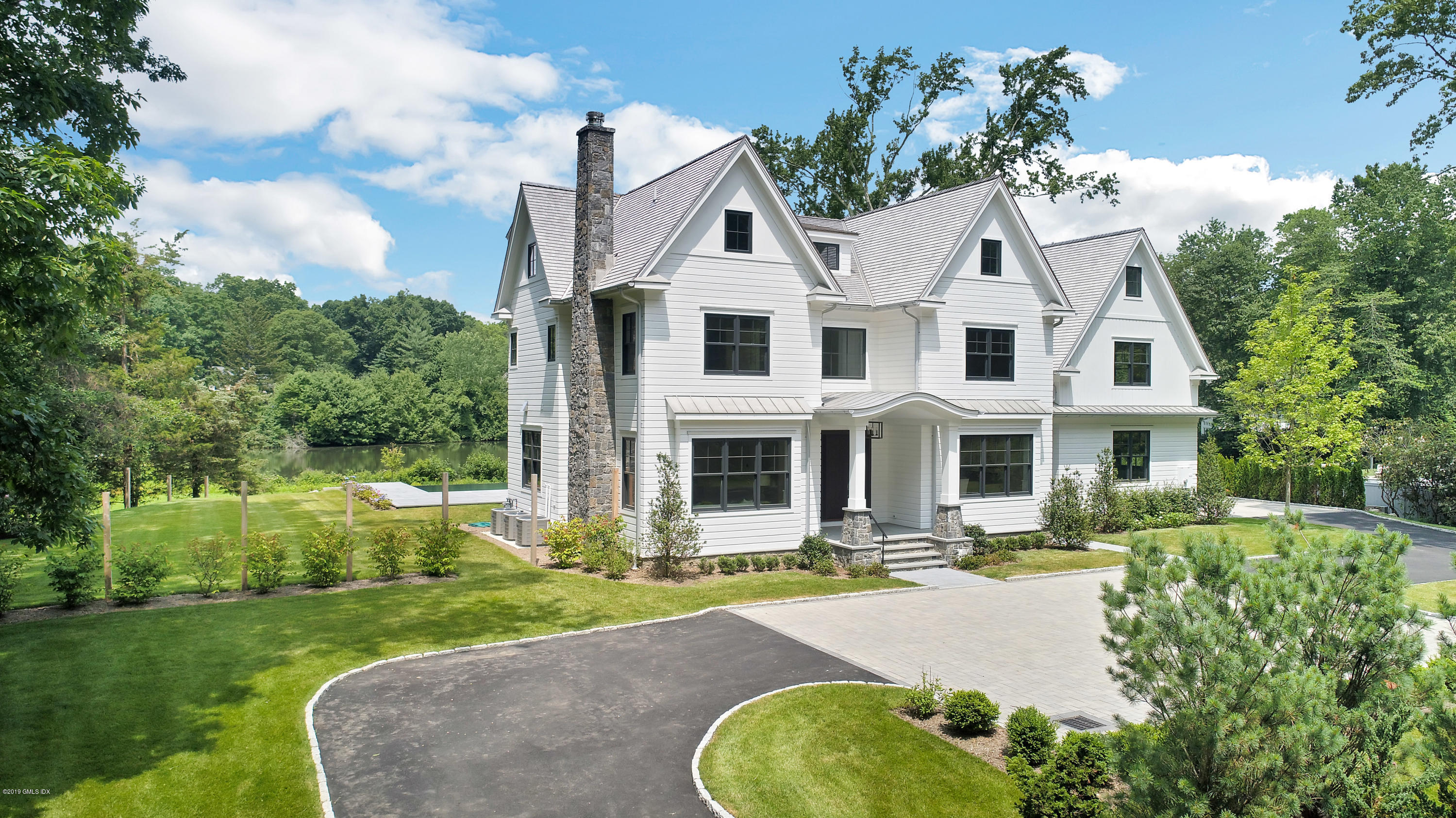 38 Birch Lane Greenwich, CT 06830 - Photo 2 of 31 a front view of a house with swimming pool and porch