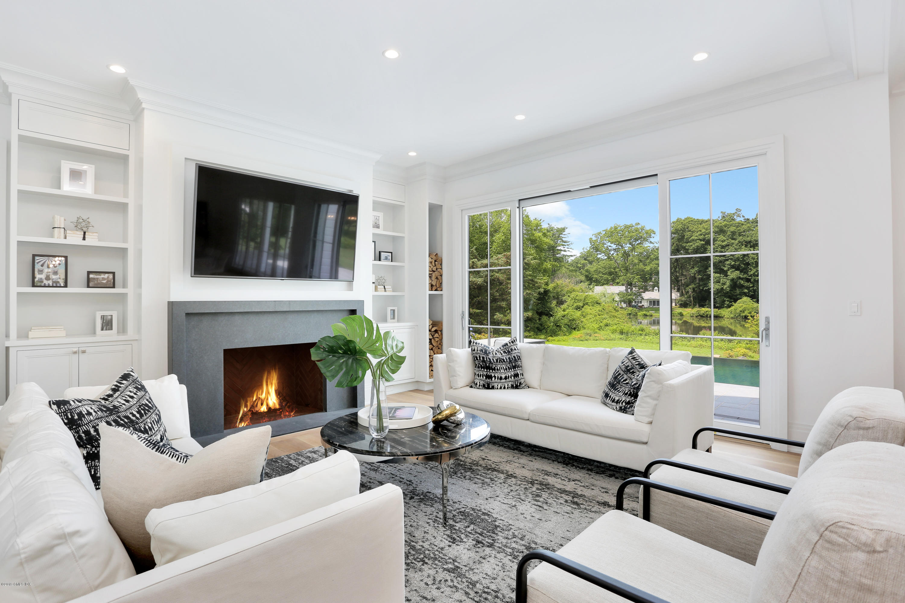 38 Birch Lane Greenwich, CT 06830 - Photo 7 of 31 a living room with furniture a fireplace and a flat screen tv
