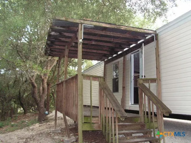 a view of a wooden house with a large tree