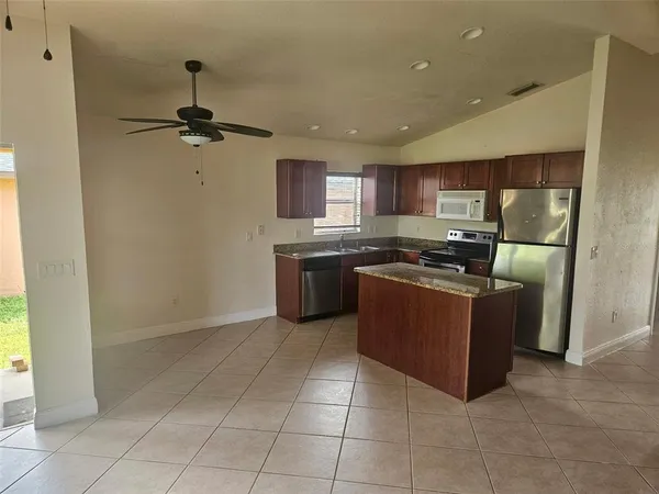a kitchen with stainless steel appliances granite countertop a stove a sink and a refrigerator