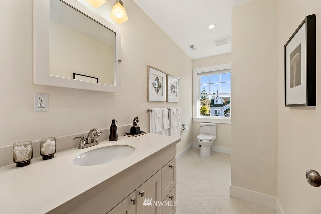 9547 Phinney Avenue North Seattle, WA 98103 - Photo 15 of 33 a bathroom with a granite countertop sink mirror and toilet