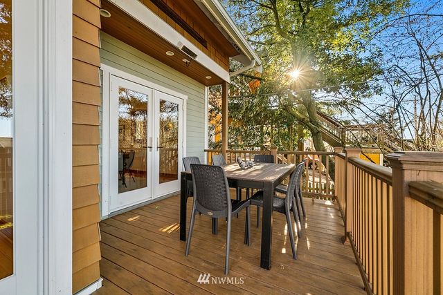 a view of a white house with a yard table and chairs