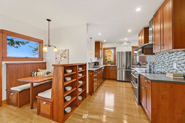 a kitchen with stainless steel appliances kitchen island granite countertop a stove a sink and a refrigerator