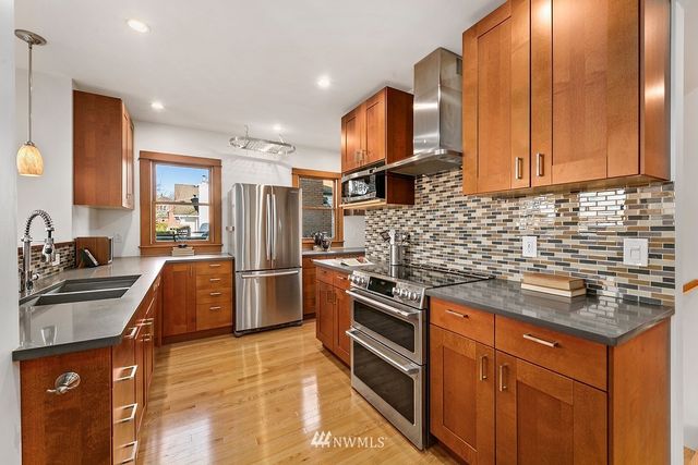 a kitchen with stainless steel appliances granite countertop a sink stove and refrigerator